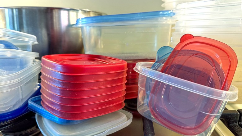 Collection of old plastic food storage containers and lids