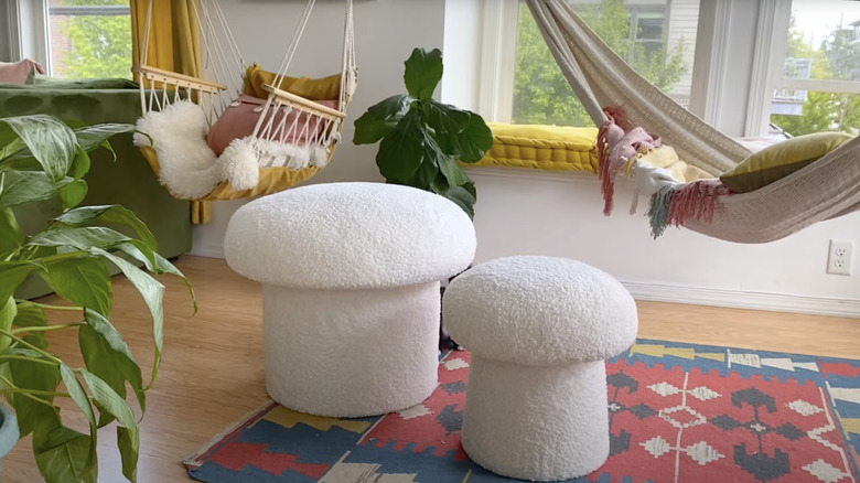 Two plush white mushroom ottomans in a sunny living room.