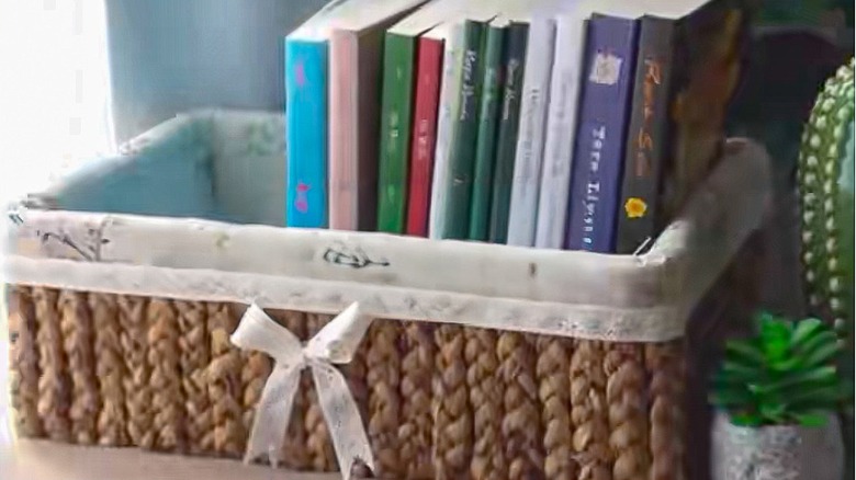 A shoe box covered with rope and linen fabric to hold books inside