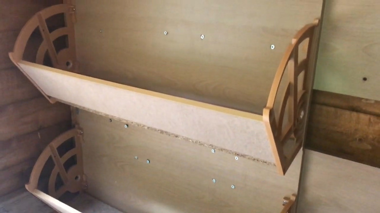 A drawer from a flip-out drawer shoe cabinet hung on a shed wall as a shelf