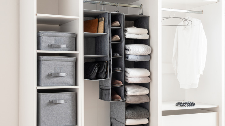 Hanging shelf organizers containing purses, shoes, and sweaters in a closet