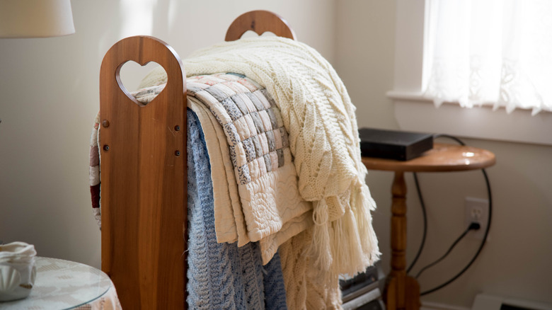 Vintage wooden quilt rack in bedroom.
