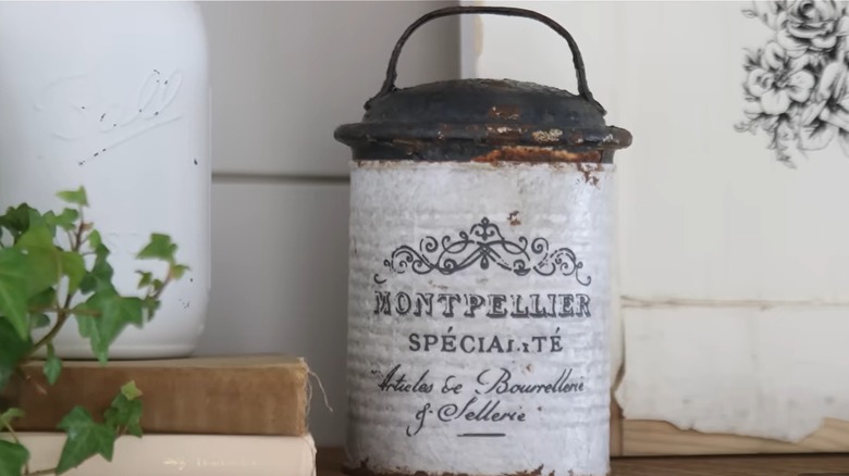 A repurposed metal can is upgraded to look like a French antique container.