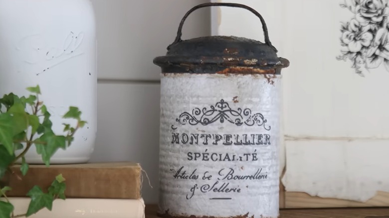 A repurposed metal can is upgraded to look like a French antique container.