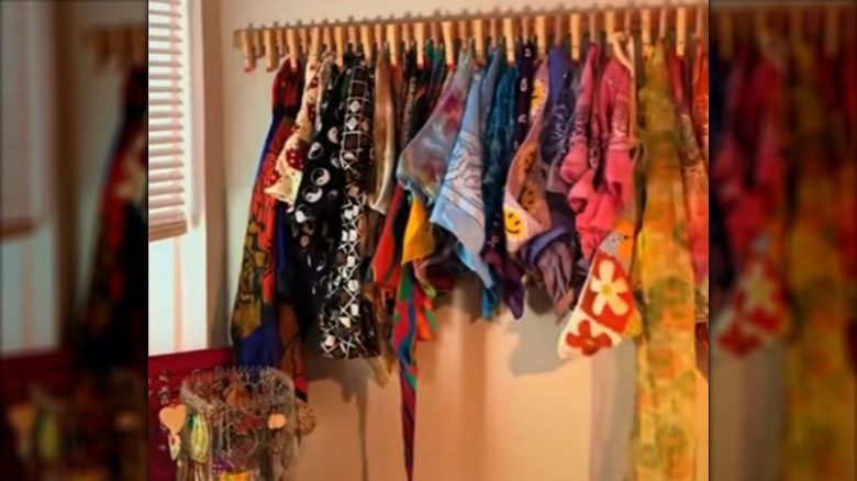 Varying colorful scarves hang from clothespins glued to a yardstick.