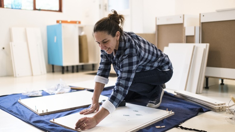 Woman assembling wood cabinets