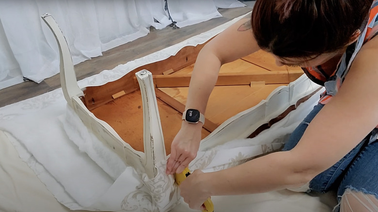 person stapling upholstery 