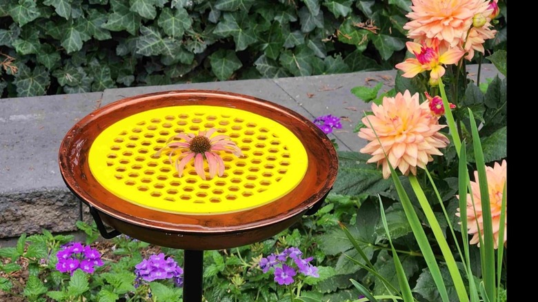 DECOHS Floating Bee Island in copper-toned birdbath in garden.