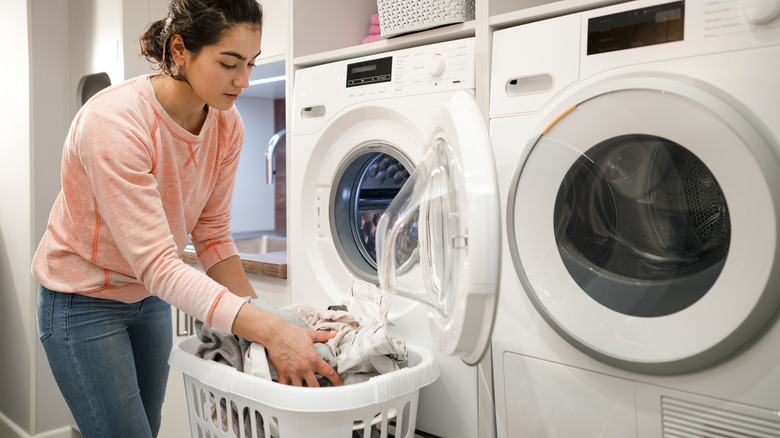 woman reaching into hamper to do laundry