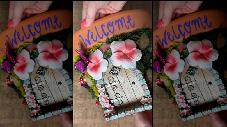 a terracotta pot is transformed into a fairy house with a few dollar tree items