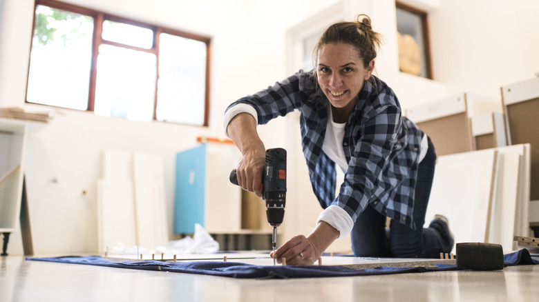 Smiling woman assembling furniture