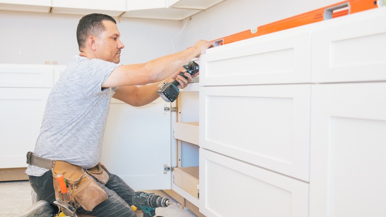Man fixing kitchen cabinet