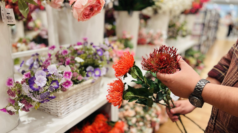 Person picks fake flowers to style in their birdcage-inspired farmhouse decor.