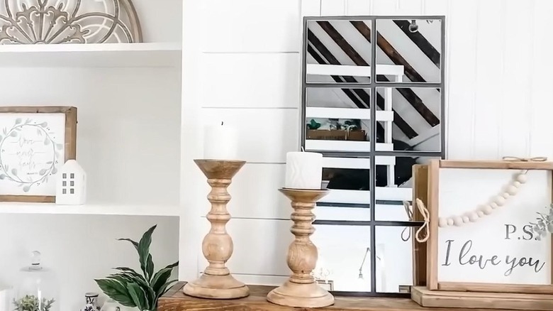 A DIY multipanel mirror rests on a mantel beside candles and a sign that reads "P.S. I love you."