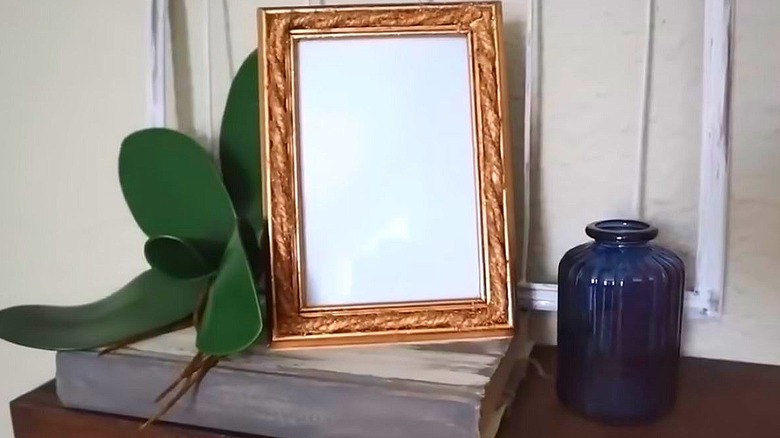 A gold picture frame with decorative jute.