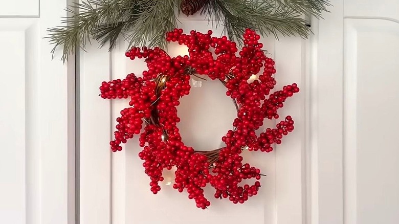 A red berry wreath with fairy lights.