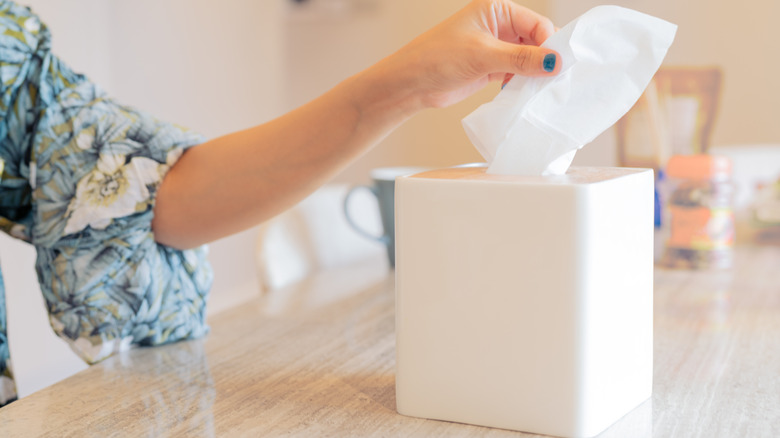 Woman pulling a tissue out of a box