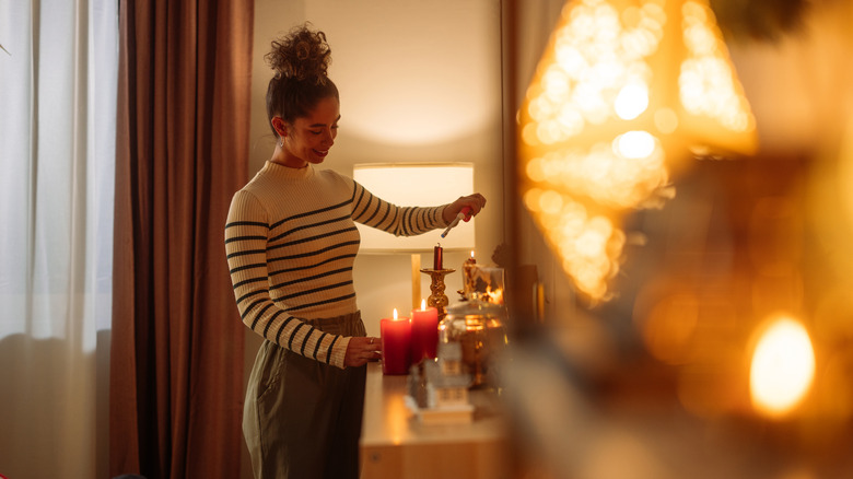 Woman lighting candles in her home