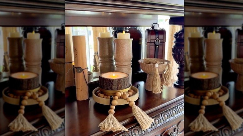 A shelf full of home decor, including a stone-look candle holder made from Dollar Tree vases