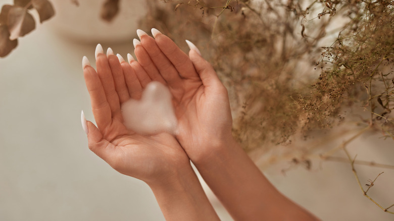 A person holding hand soap in a heart shape in their hands