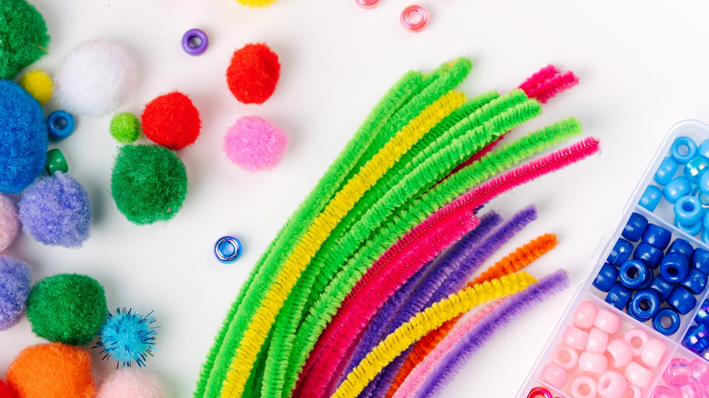 Craft supplies are scattered on a white surface