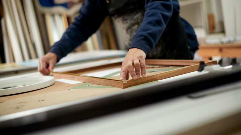 man working on picture frame