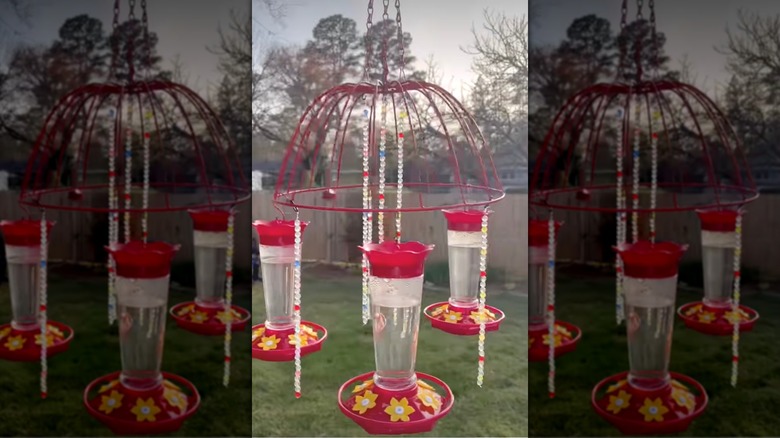 Hanging hummingbird feeder made from wire basket and nectar feeders with decorative beads.