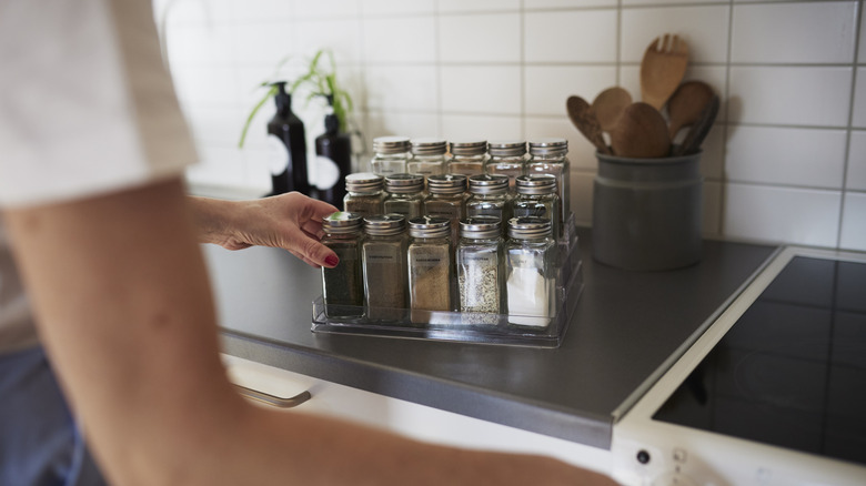 Woman taking something from spice rack