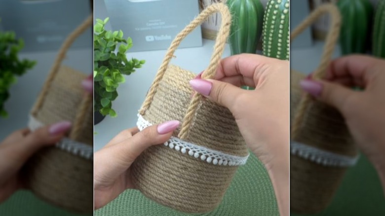 Hands attaching a handle to yogurt cups wrapped in jute rope