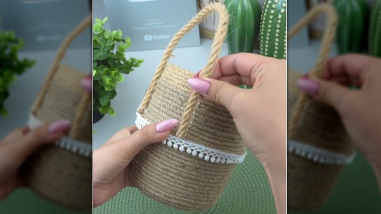 Hands attaching a handle to yogurt cups wrapped in jute rope