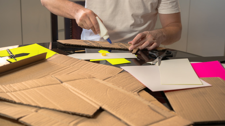 A person cutting cardboard for a crafting project