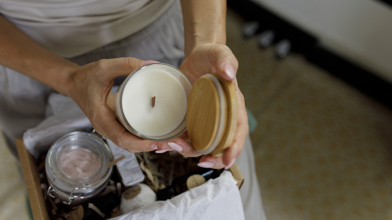 Woman opening a glass candle jar