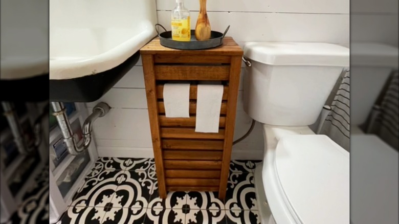 A hidden toilet roll storage solution made from leftover wood