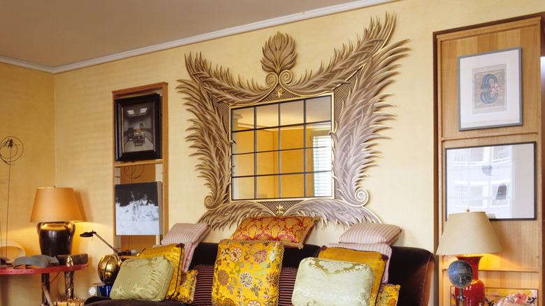 A large, fancy mirror above a couch