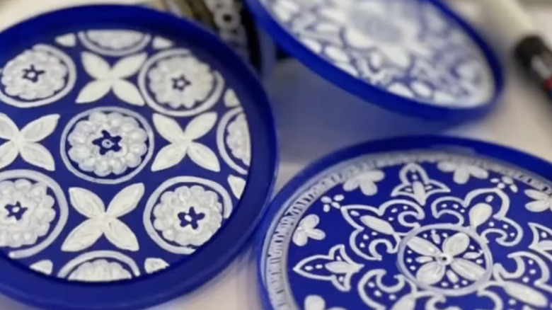 Blue plastic canister lids decorated with white Moroccan-style designs.