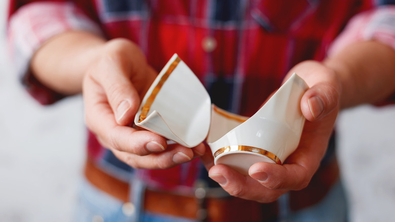 Someone holding a broken mug