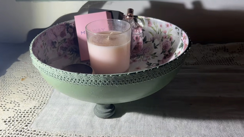 A painted bowl with items inside made from a frying pan base