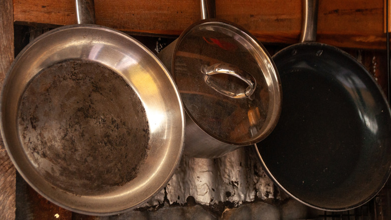 A collection of old frying pans hanging in a kitchen