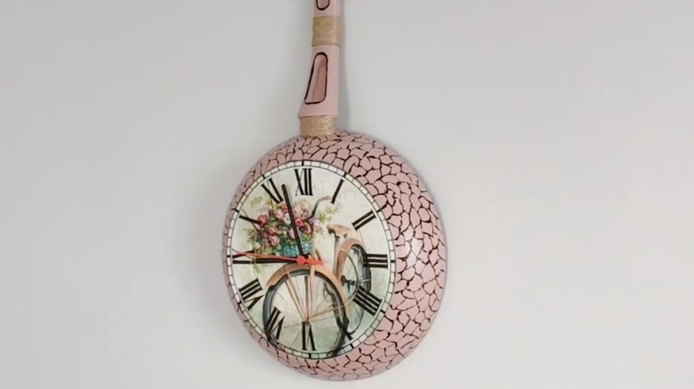 A clock made out of a frying pan hanging on wall