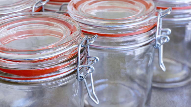 Empty glass jars with attached lids sitting next to each other