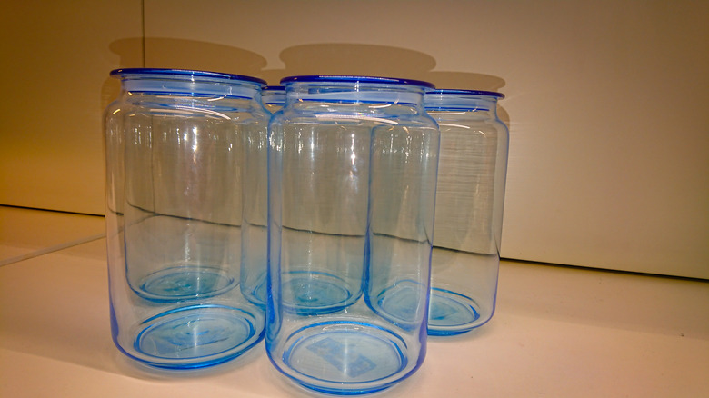 Five blue glass jars in a cabinet