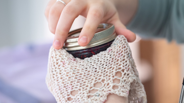 Close-up of a person closing a mason jar