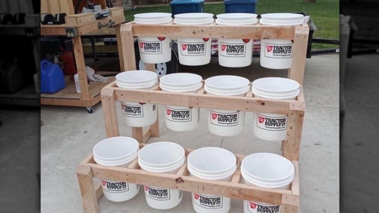 Three-level planter made from wood boards and empty paint buckets.