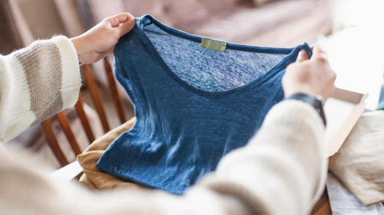 Someone holding a blue t-shirt