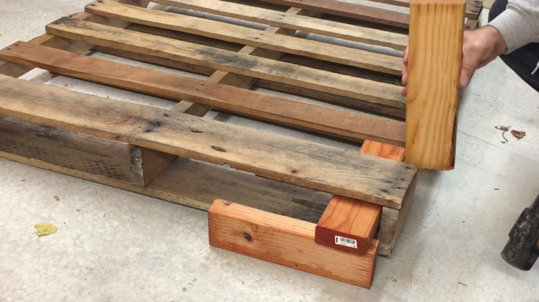Using two-by-fours to pop a pallet apart