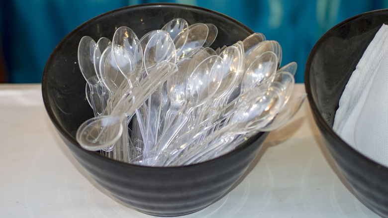 A bowl of clear plastic spoons