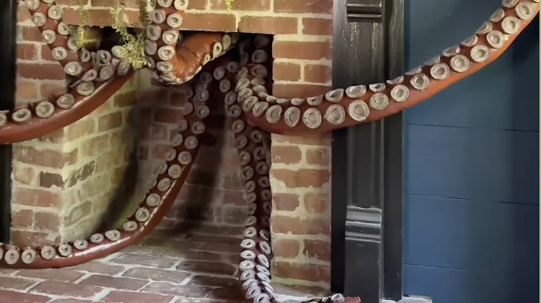 Faux tentacles reaching out of a fireplace