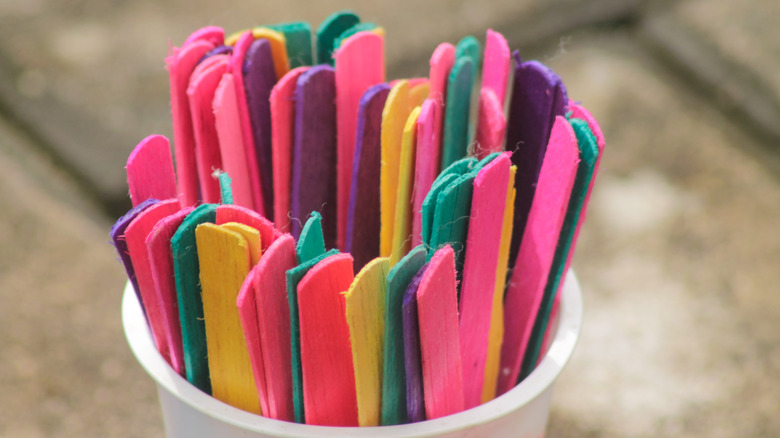 A cup of colored Popsicle sticks