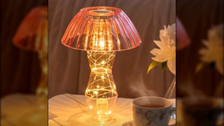 A clear pink lamp made from Dollar Tree cups, lights, and a bowl.