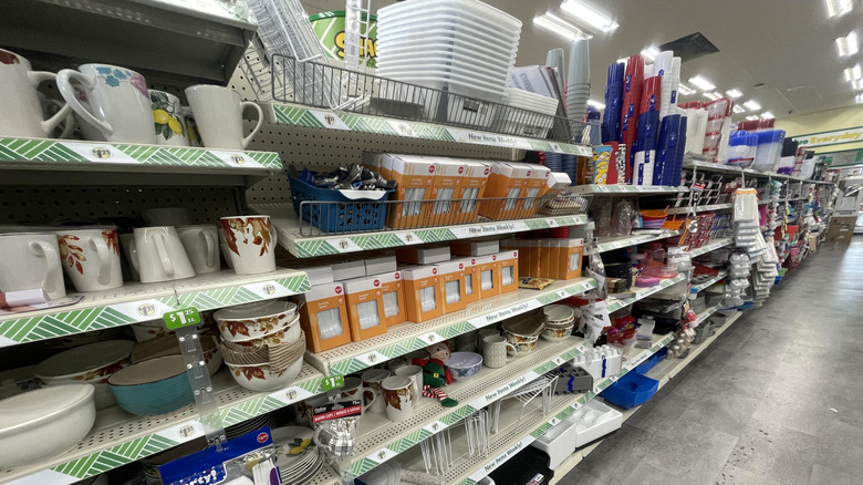 Plastic and ceramic dishware in a Dollar Tree store aisle.